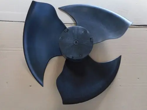 Propeller von Remeha mit drei gebogenen Blättern in schwarzer Farbe, montiert auf einem zentralen Gehäuse. Hintergrund ist ein Karton.